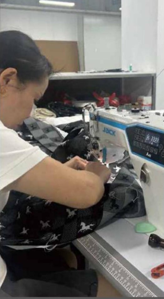 Artisan sewing the model label onto a finished mattress cover