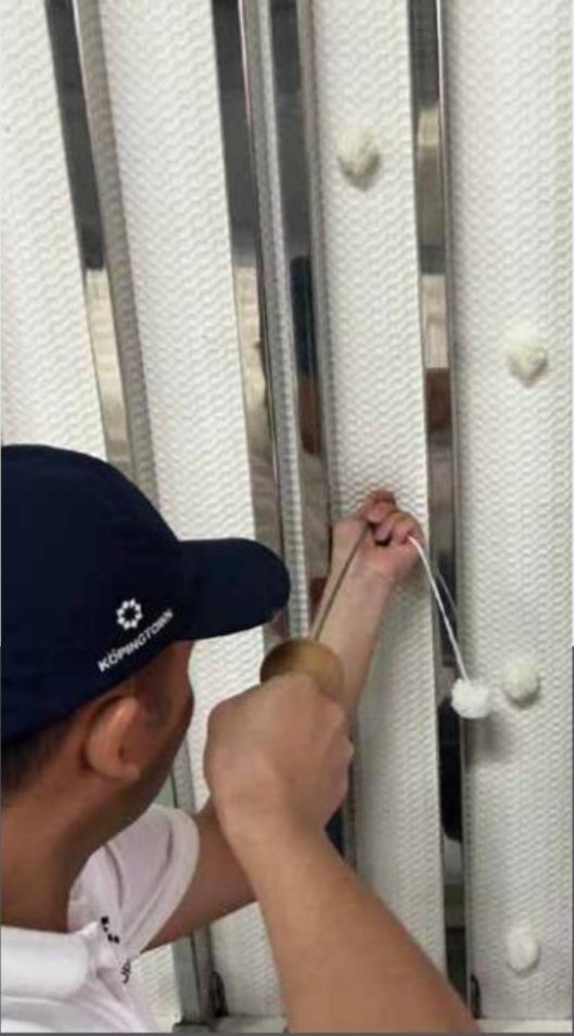 Artisan pulling a tufting needle through the mattress by hand